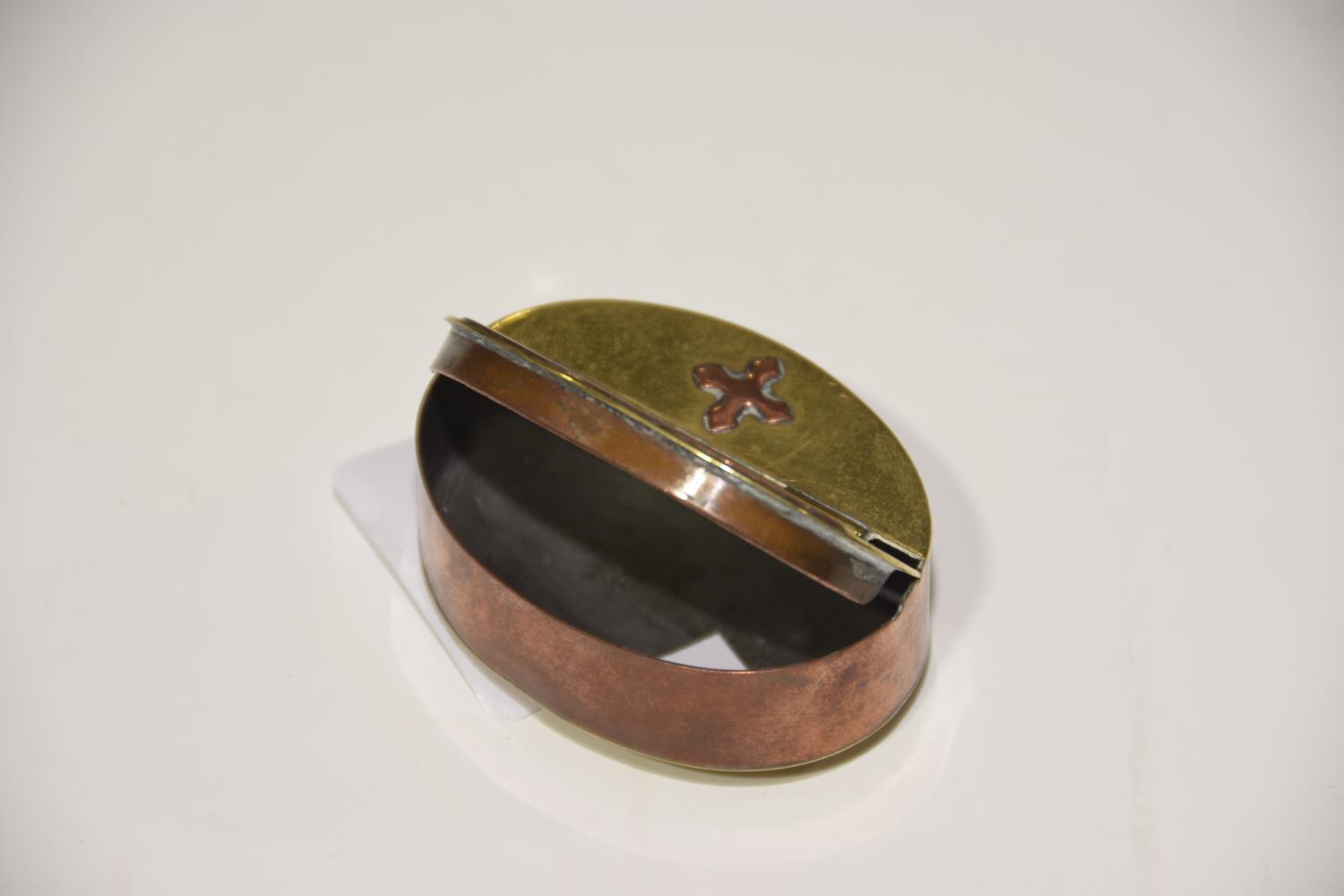 A brass and copper oval snuff box The snuff box with hinged cover, the brass domed top with copper