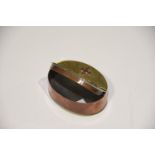 A brass and copper oval snuff box The snuff box with hinged cover, the brass domed top with copper