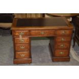 An Edwardian walnut twin pedestal desk The rectangular moulded top inset with a leather writing