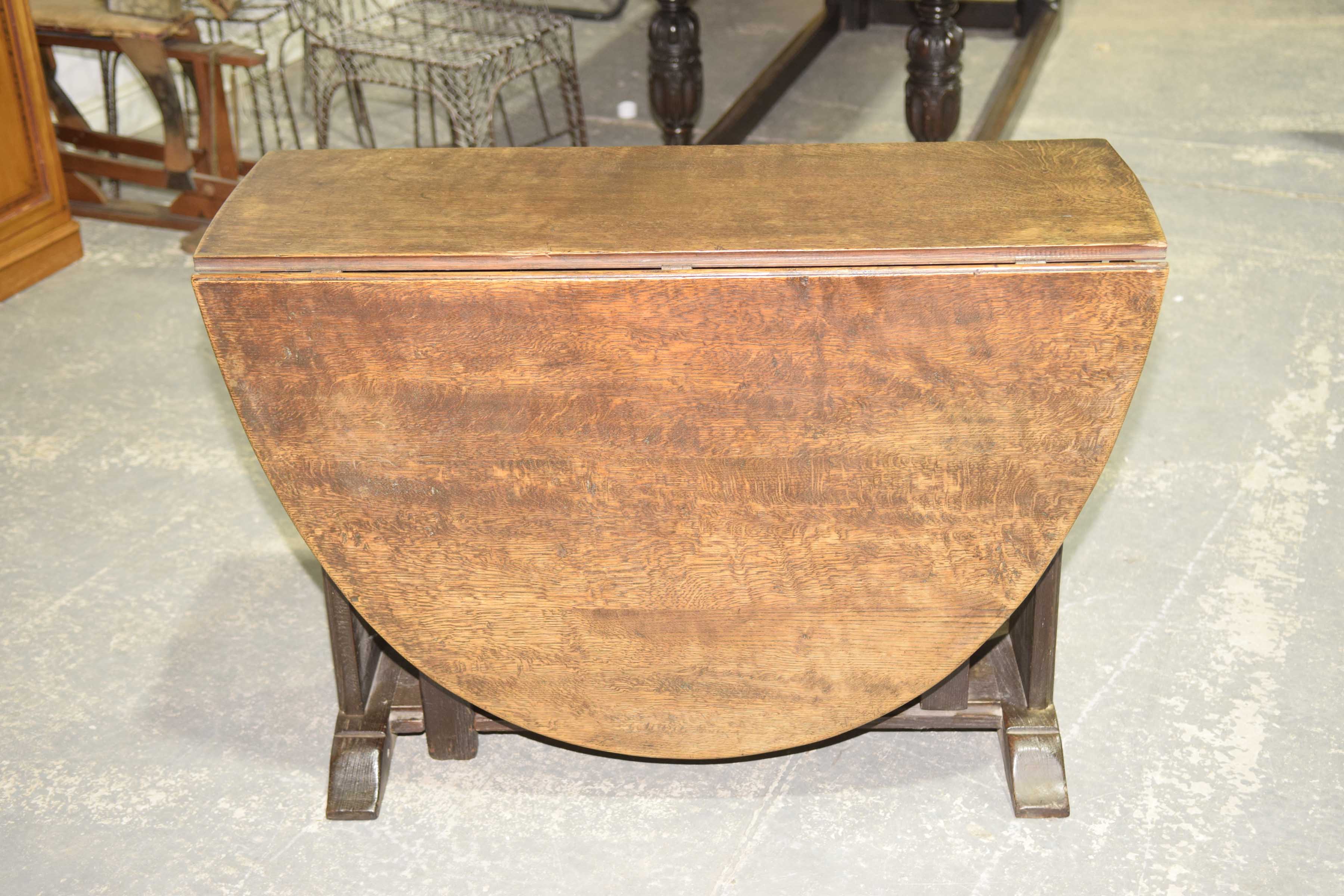 A 19th Century oval oak drop leaf dining table The oval top supported on substantial trestle type