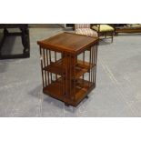 An Edwardian oak revolving bookcase Both tiers with slatted divisions, the revolving mechanism