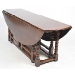 A good quality 18th Century style oak Wake table, 20th Century The oval drop leaf top supported on
