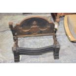 A cast iron Adams style fire grate The arched fire back cast in relief with a styalised urn and