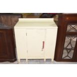 A mid 20th Century painted kitchen cabinet Having an enameled top above a single door enclosing a