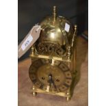 A German reproduction brass lantern clock Of typical form with an exterior saucer bell above the