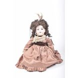 A German bisque headed doll With dark brown curly wig, open/shut blue eyes, open mouth, impressed