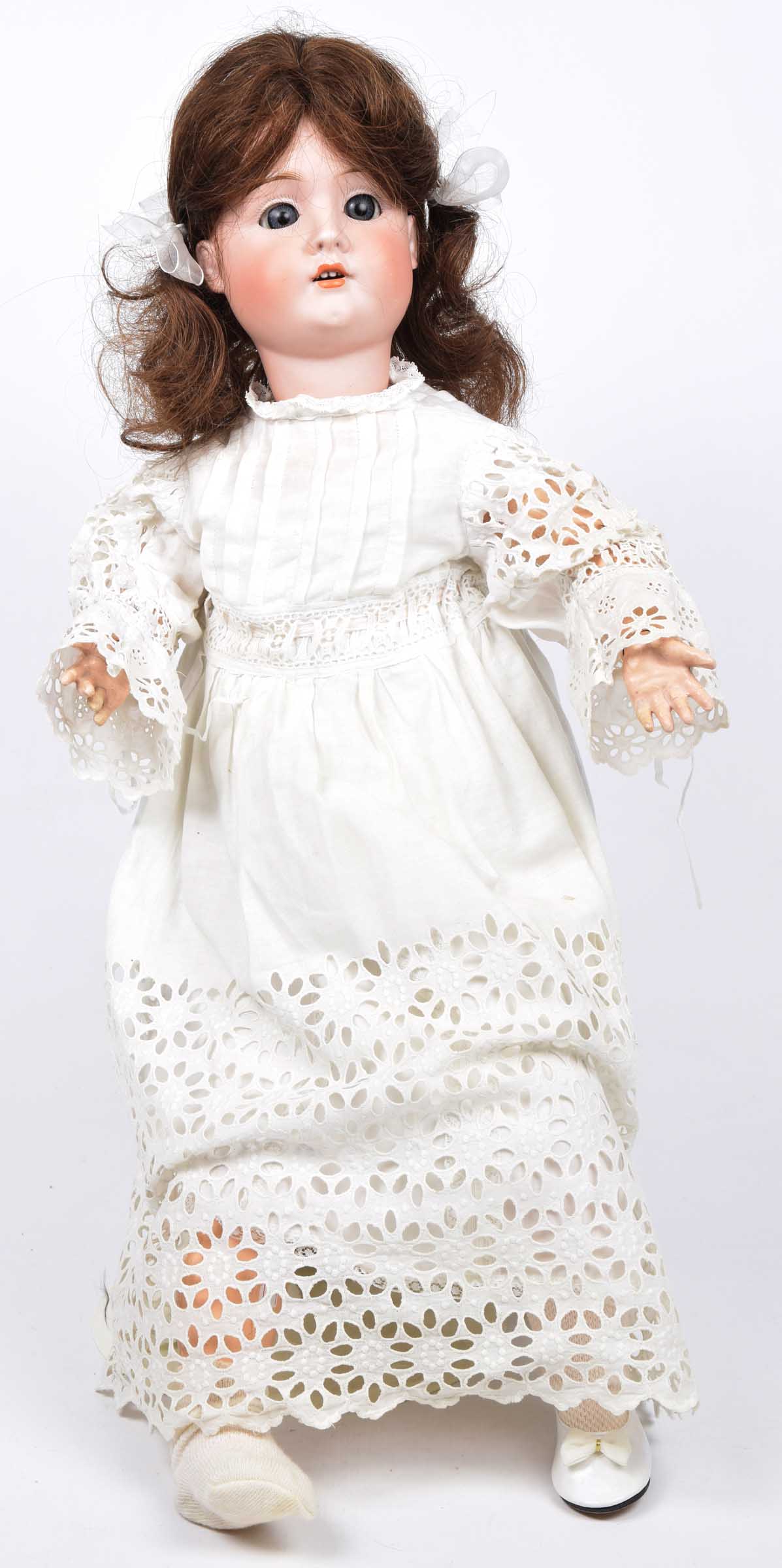 A German bisque headed doll With dark brown wig, open/shut blue eyes, open mouth, impressed marks