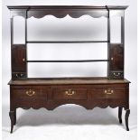 An early 18th Century oak Welsh dresser The high back with a moulded cornice above a shaped frieze