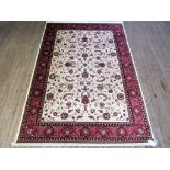 A Keshan carpet Decorated with a central floral panel on a beige background with red border, 2.3x1.