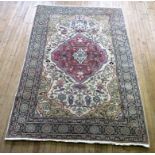 A 20th Century Persian style wool floor rug Decorated with a large central panel of floral motifs,