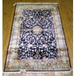 A 20th Century wool floor rug Decorated with a large central floral panel on a blue and beige