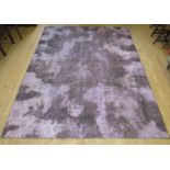 A contemporary stonewashed wool floor rug In a purple finish similar to those offered by Luke Irwin,