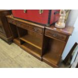 A reproduction walnut breakfront open bookcase with three frieze drawers above adjustable shelves.