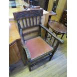 A late 19th Century oak elbow chair with bobbin turned supports and spindles