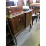 A reproduction mahogany drinks cabinet on legs of tapering square section