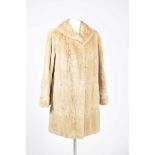 A blonde fur coat The mid length blonde fur coat with tapered lapel and brown and gold silk