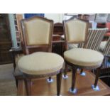 A set of four French style walnut and upholstered dining chairs, each with a padded back above