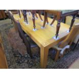 A contemporary light oak dining table, raised upon substantial legs of square section, along with