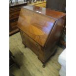 An Edwardian mahogany bureau, with fall front over three drawers, raised on short legs and ball