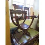 A 17th Century style carved hardwood X-frame elbow chair