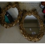 A pair of oval wall mirrors set in foliate and ribbon mounted gilt finished frames