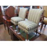 A pair of early 20th Century low seat chairs on legs of tapered square section