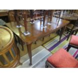 A reproduction French style oak draw-leaf extending dining table