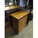 A modern pine chest of four drawers.