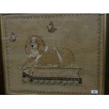 A 19th Century needlework picture of recumbent Spaniel and butterflies, framed and glazed.