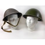 Two British painted steel Army helmets, late 20th Century The first with green painted shell,