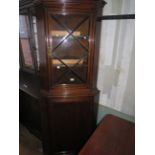 An oak floor standing corner cabinet with glazed top section and cupboard base