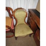 A Victorian walnut framed spoon back nursing chair, decorated with carved detail and upholstered