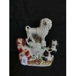 A 19th Century Staffordshire clock figure group, the central clock surrounded by two Spaniels and