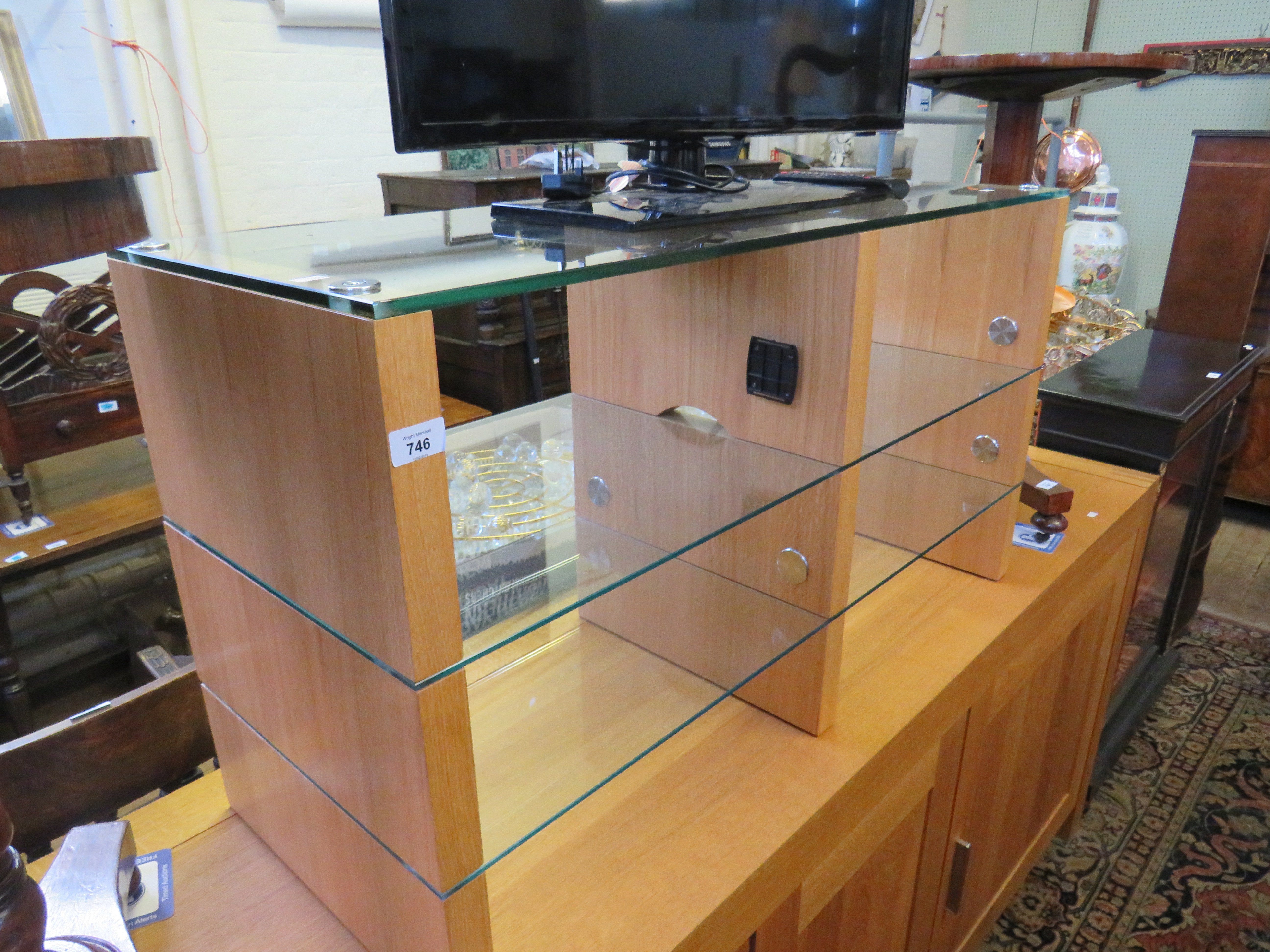 A contemporary light oak and glass TV stand