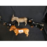 Three Royal Doulton Dachshund models together with a Beswick model donkey (4)