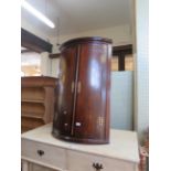 A George III oak and mahogany crossbanded bowfront hanging corner cupboard