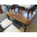 An Edwardian walnut extending dining table on turned legs with canted corners