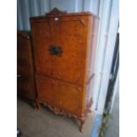 A burr walnut Queen Anne style drinks cabinet, two doors over two doors.