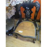 A Victorian black lacquered side chair The arched back decorated with mother of pearl inlay over a