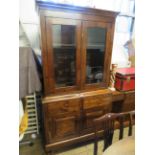 An early 20th Century stained pine side cabinet with glazed top section over a base with two drawers
