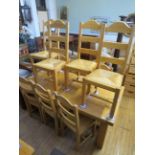 A contemporary light oak extending dining table on legs of square section along with ten