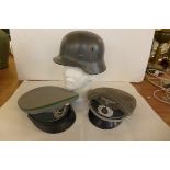 A grey painted metal German soldiers helmet, mid 20th Century, the grey helmet with eagle and