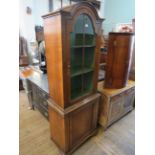 A reproduction Georgian style walnut glazed bookcase, having an arched top above a single glazed