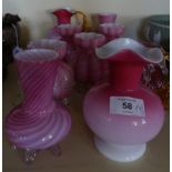 A mixed lot of various coloured glassware comprising six bulbous pink vases raised on clear glass