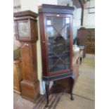 A 19th Century mahogany freestanding corner display cabinet with a blind fretwork frieze raised upon