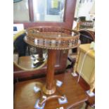 A mid 19th Century rosewood pedestal lamp table with circular top and a spindled gallery
