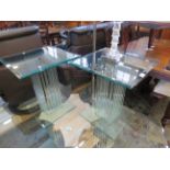 A pair of contemporary glass top lamp tables, each square table top supported on an arrangement of