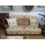 A modern hardwood and upholstered three seater settee with a similar but non conforming hardwood and