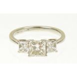 A platinum diamond three stone ring The square shaped diamond with similarly shaped diamond sides,