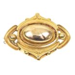A mid Victorian brooch The oval polished dome within an openwork cannetille surround, to the